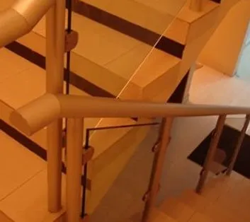 Barandal de cristal en escalera con peldaños de madera