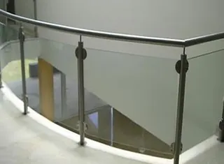 Barandal curvo de cristal con pasamanos en escalera interior
