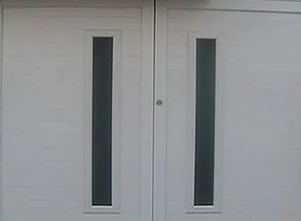 Portón de aluminio blanco de dos hojas con ventanillas